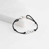 Pulseira GRINE LOVE preta em aço inoxidável com detalhe brilhante e fecho ajustável sobre base branca