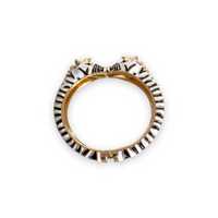 Pulseira rígida GRINE com padrão zebra em esmalte preto e branco e detalhe de cabeças de zebra em metal dourado.
