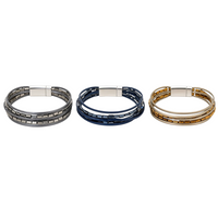 Pulseira Tami GRINE em pele sintética com cristais e fecho magnético, disponível em cinzento, azul e dourado.