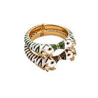 Pulseira rígida GRINE com design de zebra em esmalte branco e verde, detalhe em metal dourado e abertura de mola.