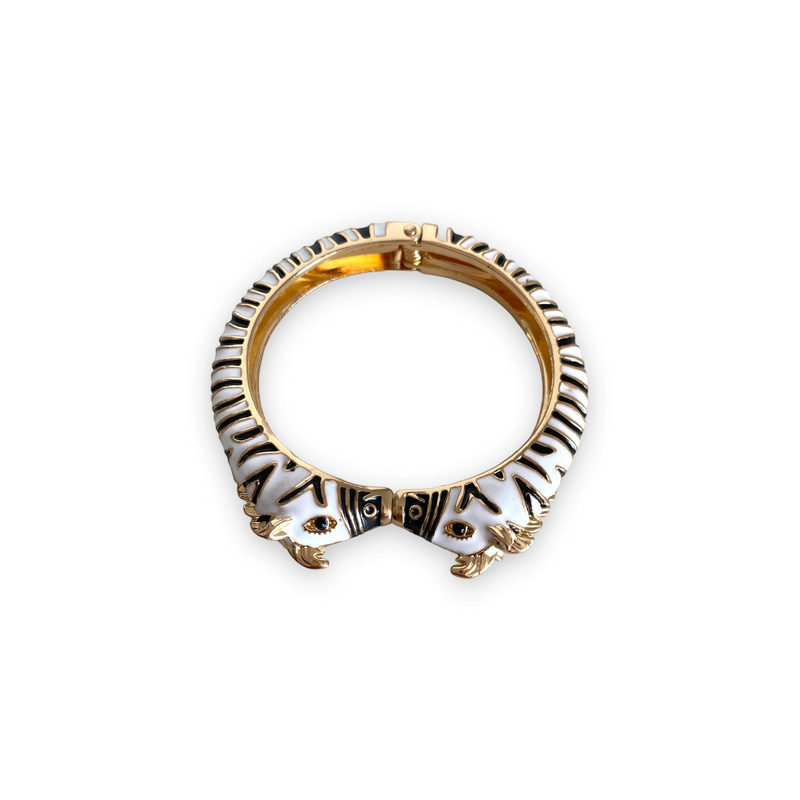 Pulseira rígida GRINE com padrão zebra em esmalte preto e branco, feita em cobre com abertura de mola.
