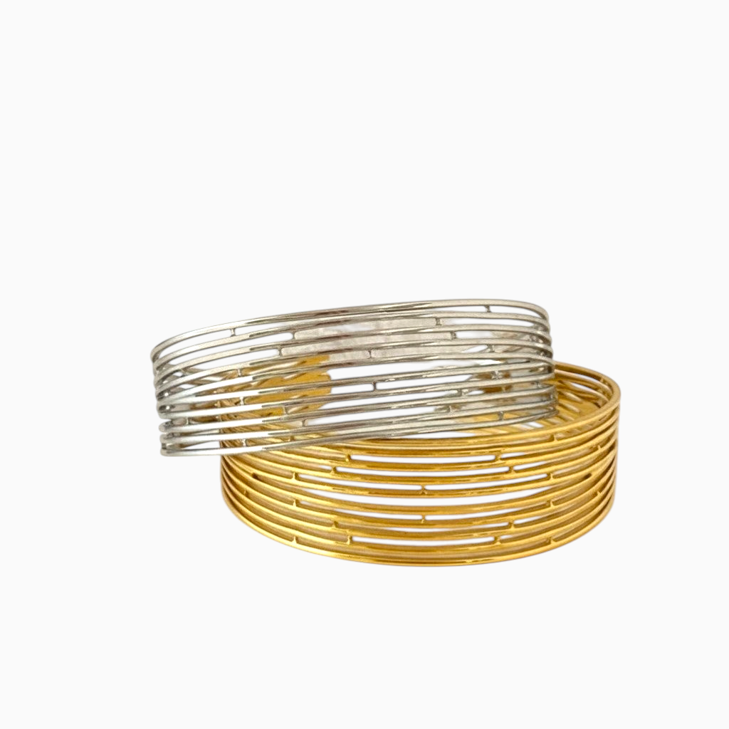 Pulseiras GRINE em aço inoxidável com design de linhas paralelas, uma prateada e outra dourada, acabamento polido.