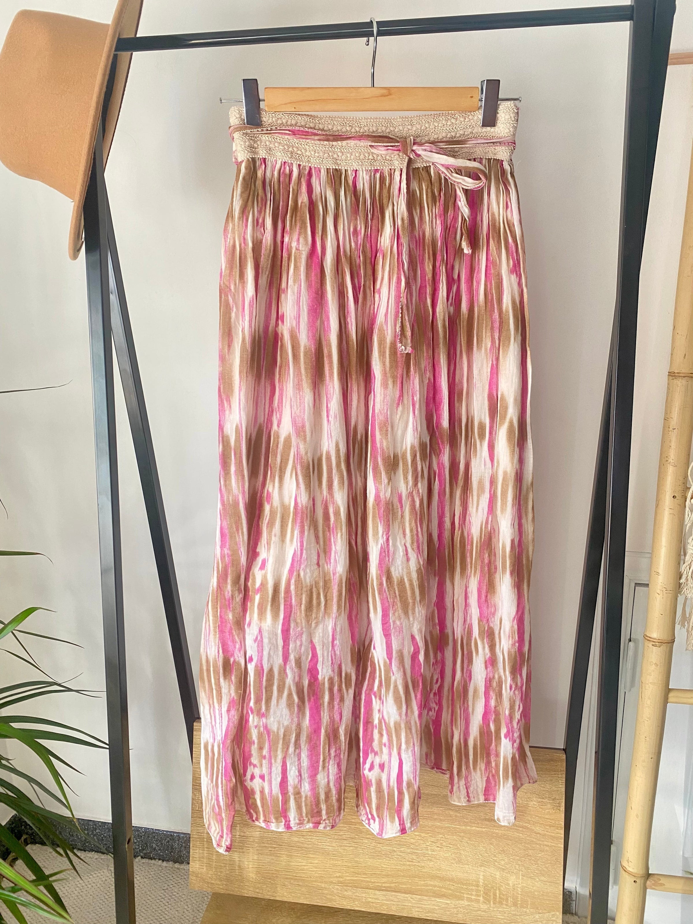 Saia comprida GRINE em algodão com padrão tie dye rosa e bege, cintura elástica com cordão e forro interior.