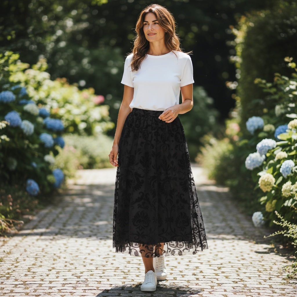 Modelo GRINE veste saia midi preta em tule com relevos de veludo e cintura elástica em jardim florido