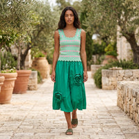 Modelo veste saia midi GRINE verde esmeralda com flores 3D em tecido técnico estruturado e top de malha em jardim
