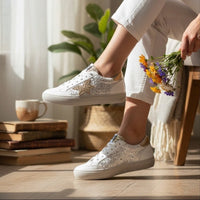 Sapatilhas GRINE Aura brancas com detalhes em glitter e estrela lateral, usadas por modelo com flores