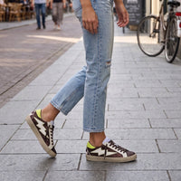 Sapatilhas GRINE Chocolate Corina com brilhos, detalhes neon e padrão animal em look casual com calças de ganga
