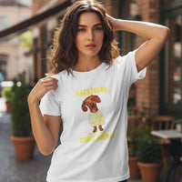 Mulher a usar t-shirt branca de algodão GRINE com estampado de cão Dachshund e frase inspiradora em ambiente urbano
