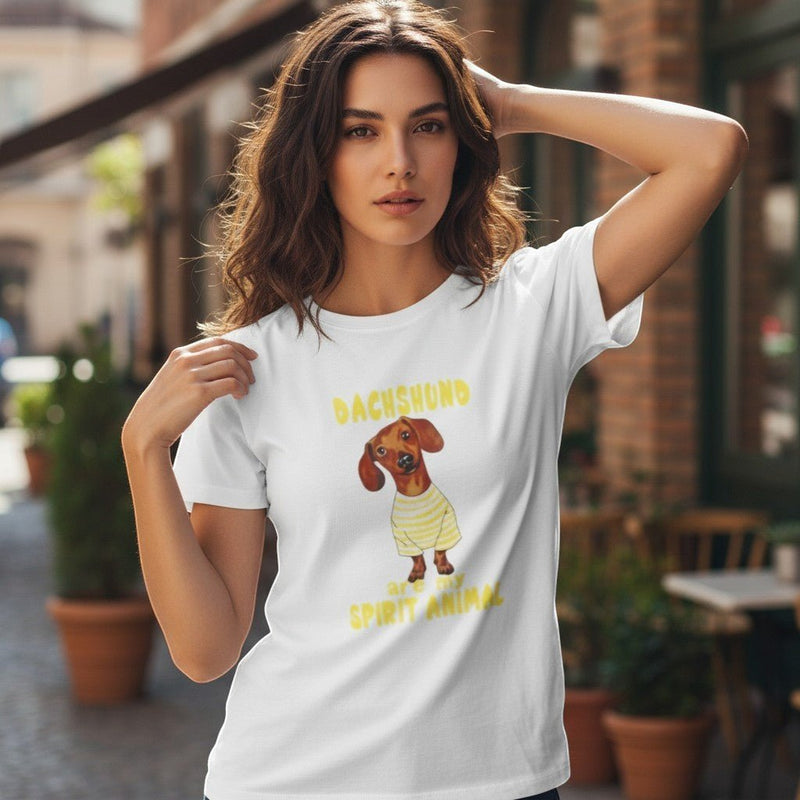 Mulher a usar t-shirt branca de algodão GRINE com estampado de cão Dachshund e frase inspiradora em ambiente urbano