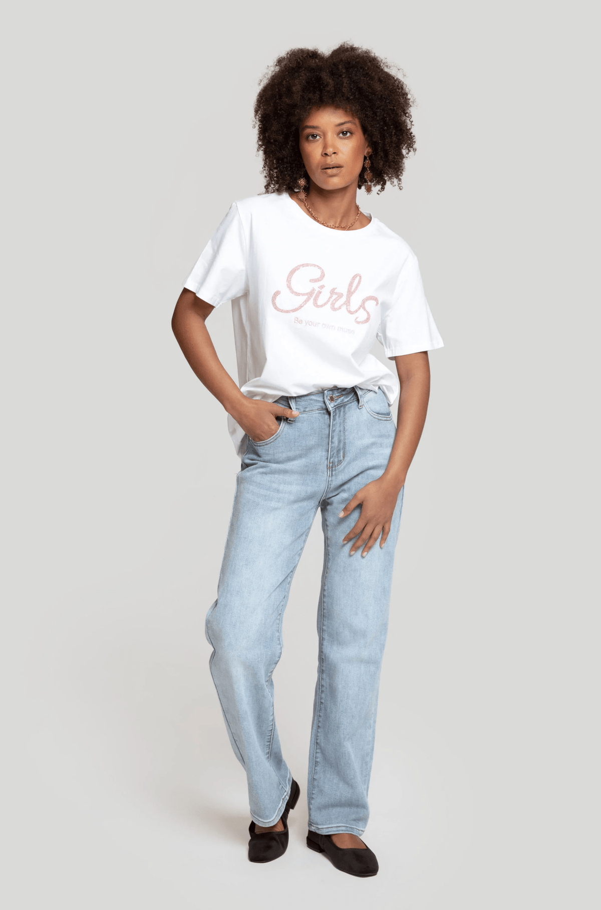 Modelo veste t-shirt branca GRINE de algodão com estampa Girls, manga curta, gola redonda e corte largo casual.