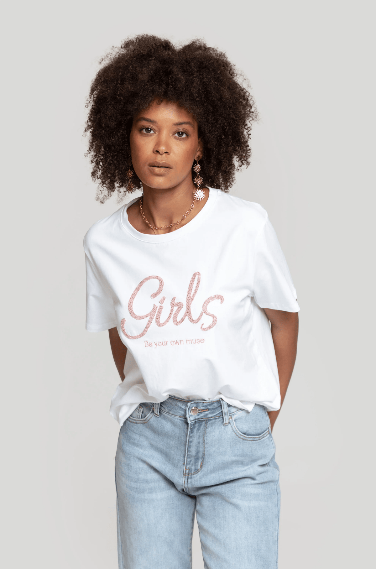 Modelo veste t-shirt branca GRINE de algodão com estampa Girls e gola redonda, estilo largo e casual.