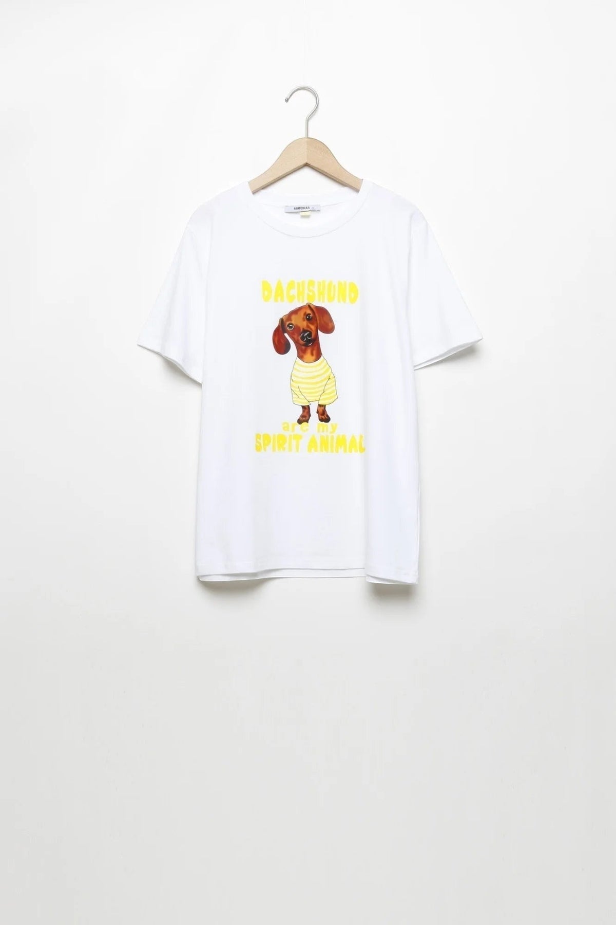 T-shirt branca de algodão GRINE com estampado gráfico de cão Dachshund e texto em amarelo, gola redonda e manga curta.
