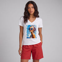 Modelo veste T-shirt branca GRINE com decote em V e estampa pop art de mulher, combinada com calções vermelhos.