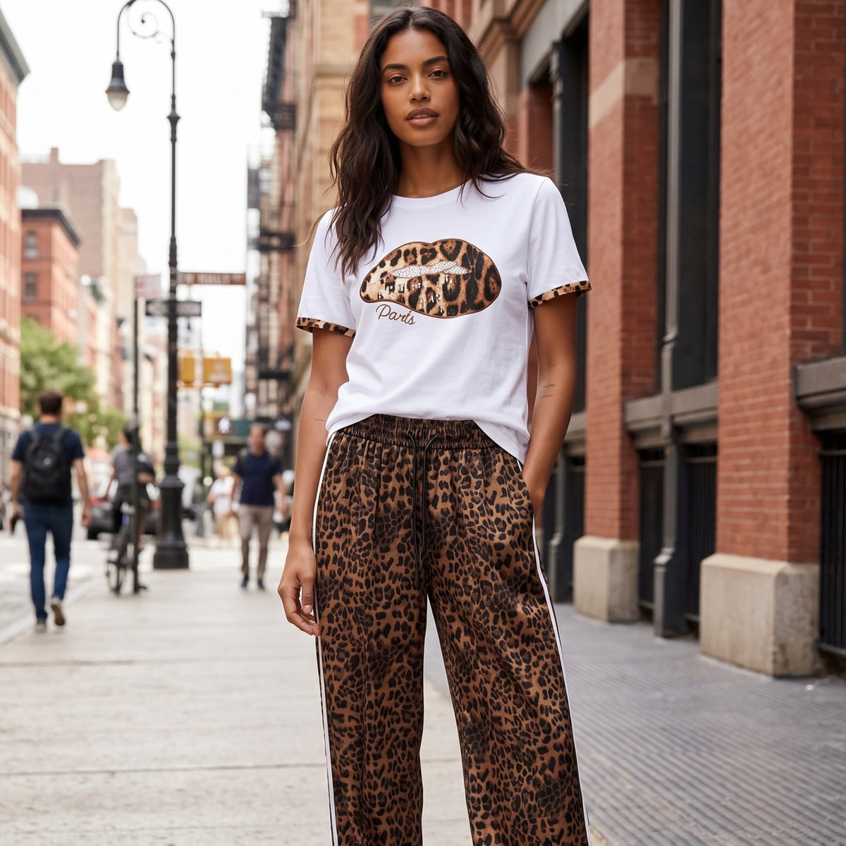 Modelo veste t-shirt branca GRINE de algodão com estampado de lábios em animal print e brilhantes na rua