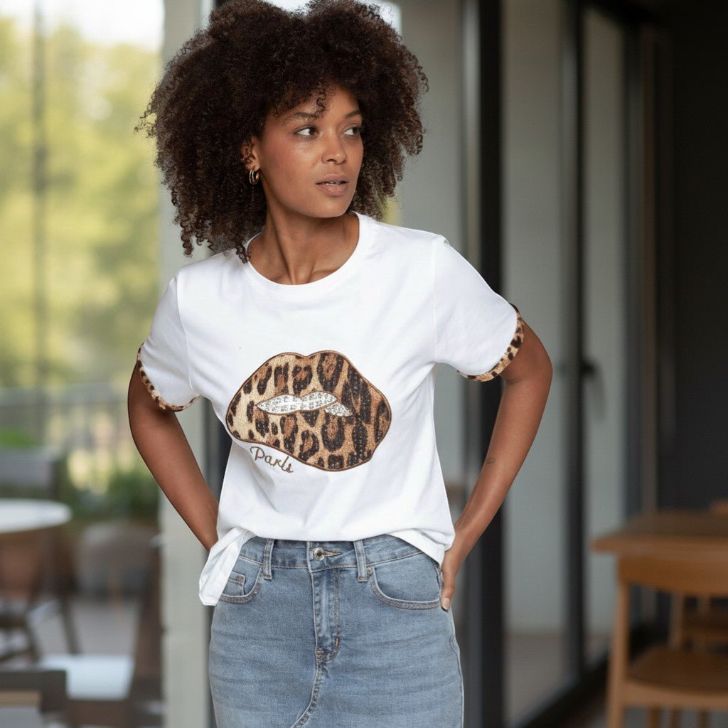 Modelo veste T-shirt branca GRINE de algodão com estampado de lábios em animal print e detalhes de brilhantes