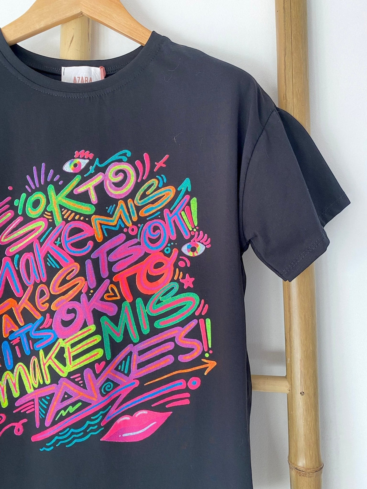 T-shirt preta GRINE de algodão com estampado grafiti colorido e a frase It's ok to make mistakes
