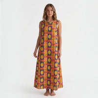 Modelo veste vestido comprido GRINE em algodão com padrão multicolorido de laranjas, limões e flores, corte fluido.