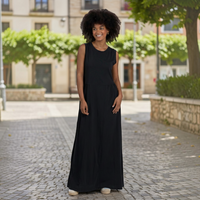 Modelo com vestido comprido preto GRINE em algodão com corte evasê, decote redondo e sem mangas ao ar livre