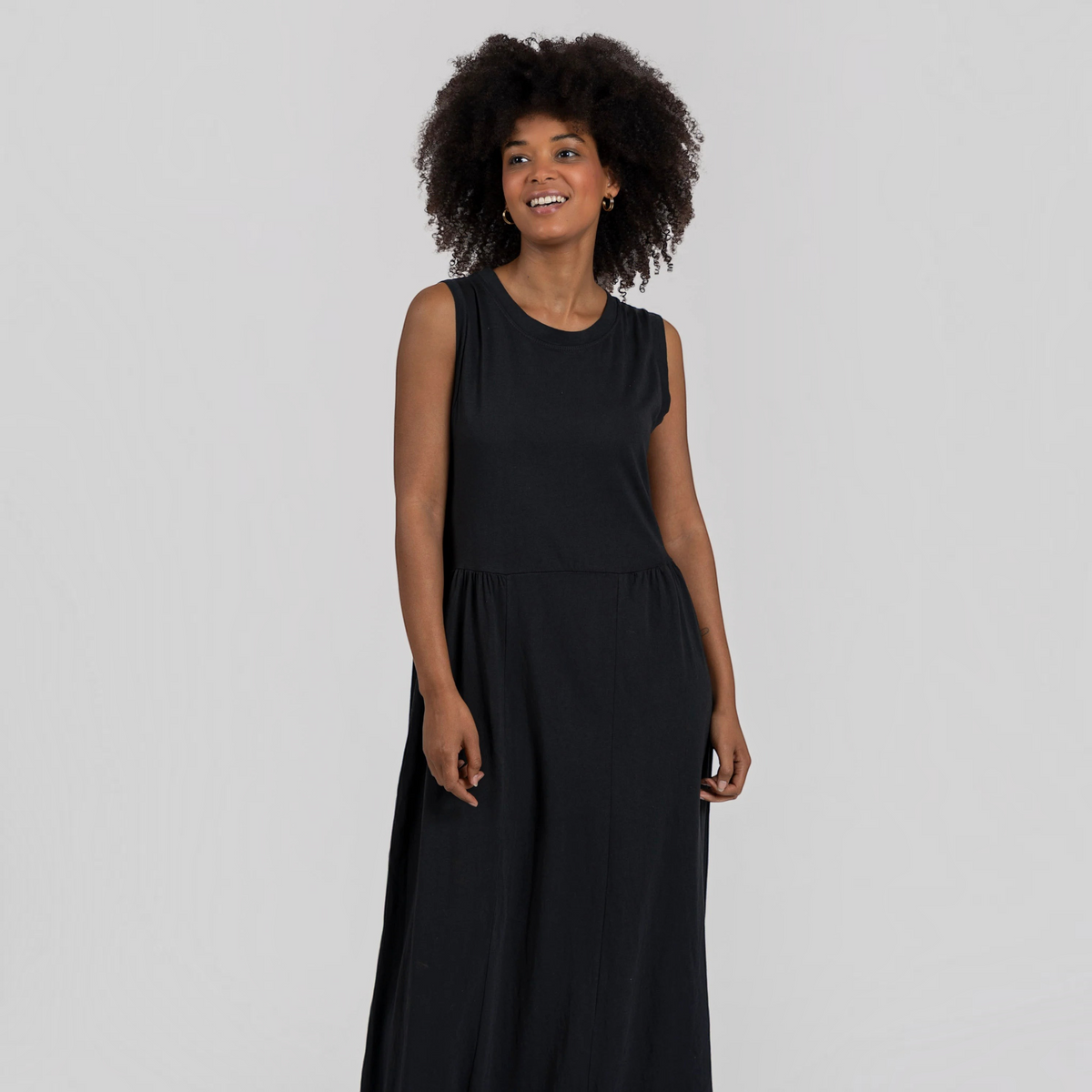 Modelo com vestido comprido preto GRINE em algodão com corte evasê, decote redondo e sem mangas
