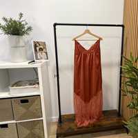 Vestido comprido GRINE em tom terracota com alças finas, decote em V e detalhes delicados em renda na base.