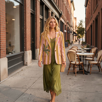 Modelo GRINE veste vestido comprido verde oliva em renda crochet com alças ajustáveis e blazer às riscas