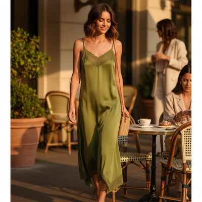 Mulher a usar vestido comprido GRINE verde oliva em cetim com detalhes de renda tipo crochet e alças ajustáveis