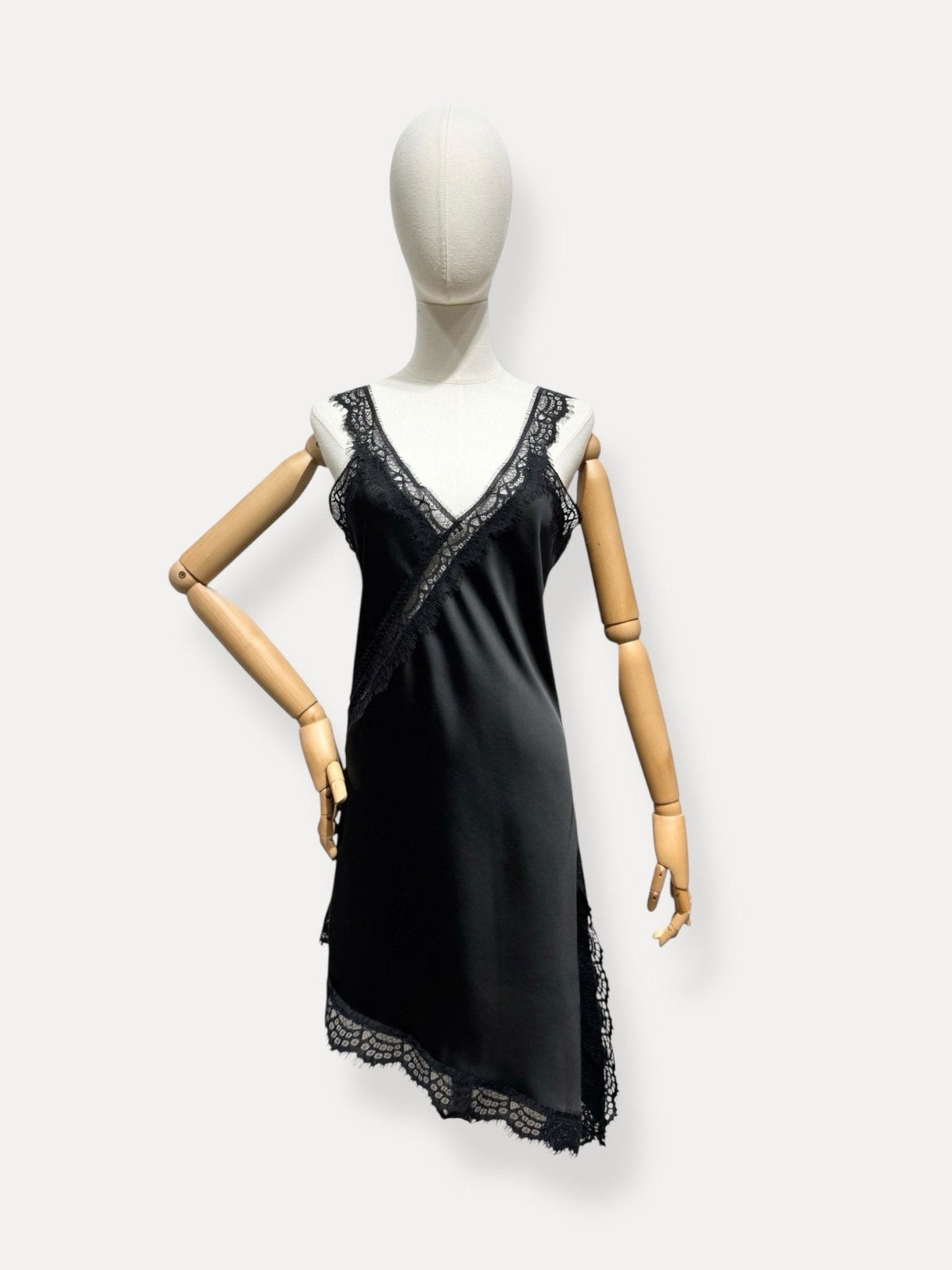 Vestido curto acetinado preto GRINE com decote em V, detalhes em renda e bainha assimétrica num manequim