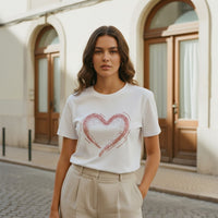 GRINE white cotton t-shirt with short sleeves, round neck, and a rose gold sequin heart graphic. Relaxed fit with a slightly wider back.