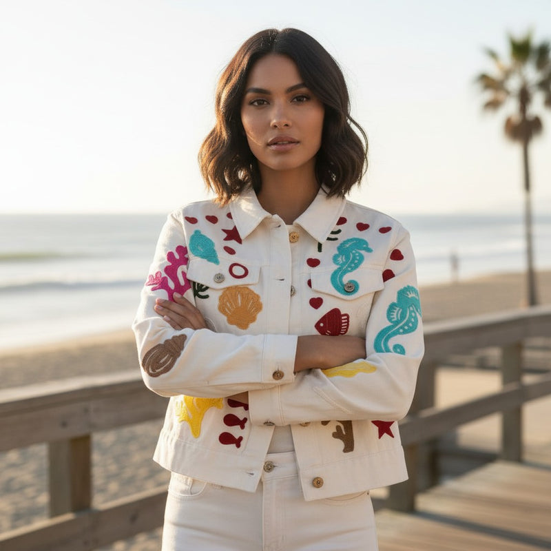GRINE white denim jacket with colourful embroidered marine life motifs like seahorses, shells, and coral. 100% cotton.