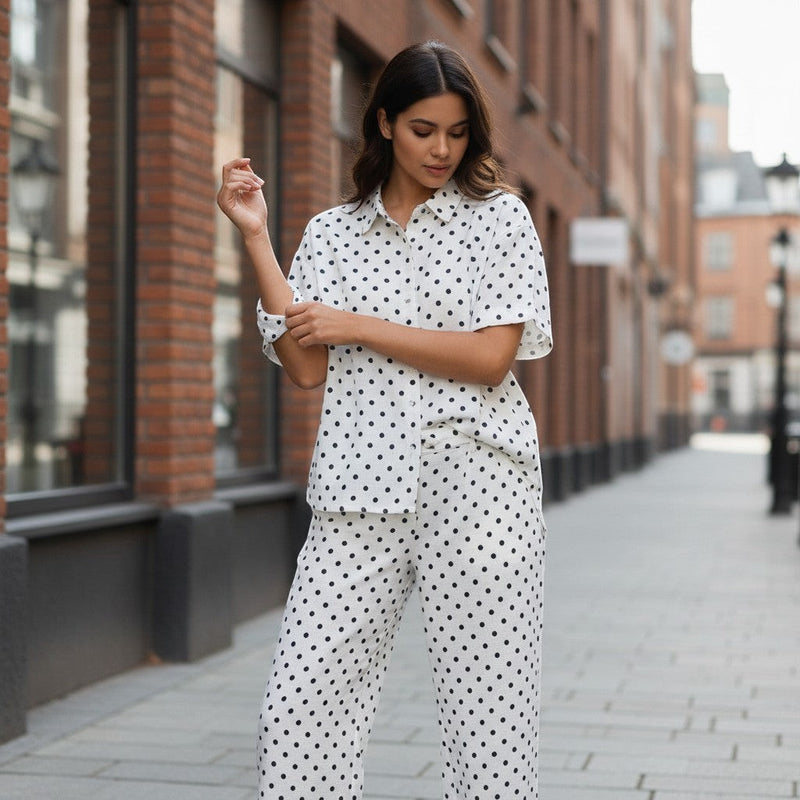 GRINE pearl white cotton shirt with black polka dots, short sleeves, button front, side slits, and longer back. Matches polka dot trousers.
