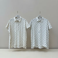 GRINE white pearl cotton shirt with dark brown polka dots, short sleeves, button-up front, side slits, and longer back.