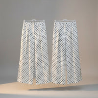 GRINE white pearl cotton trousers with black polka dot print, side slits, and button closure.